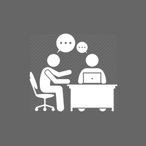 icon of two persons sitting at a desk with thought bubbles above their heads.
