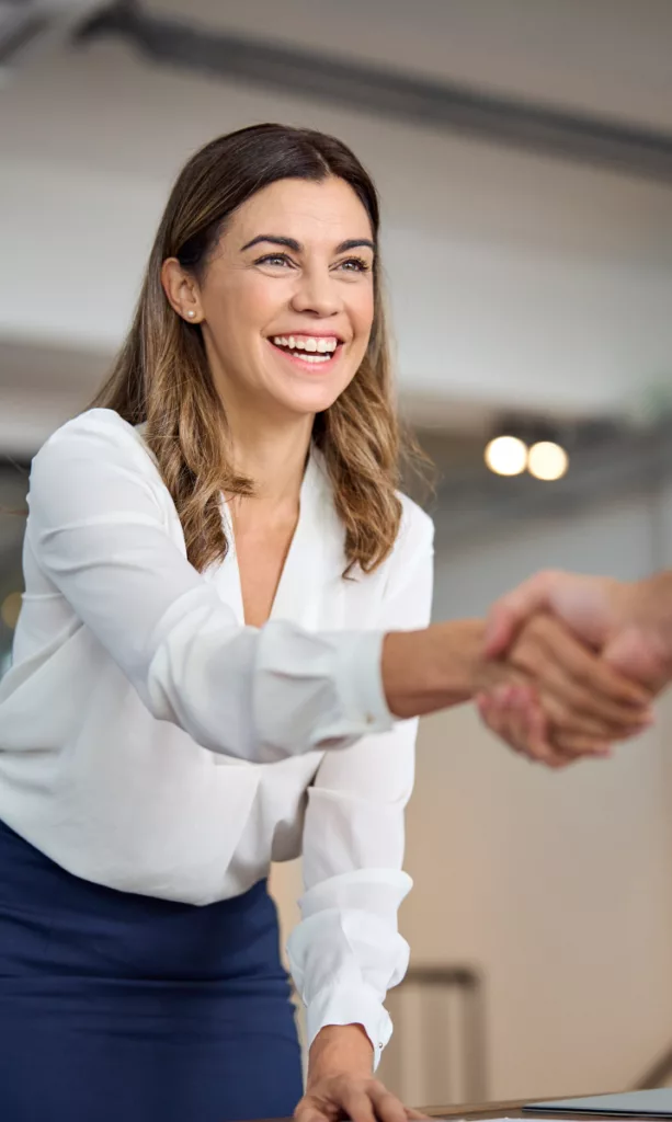 business woman smiling while shaking hands